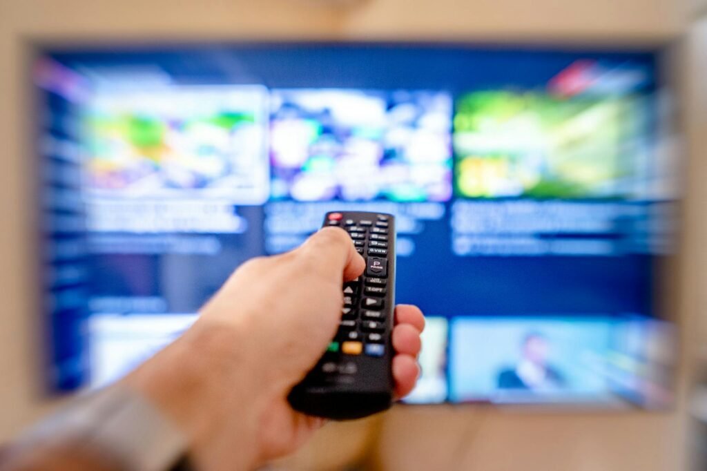 Modern IPTV player interface displaying channels and media library with dark theme, multiple screens showing streaming content