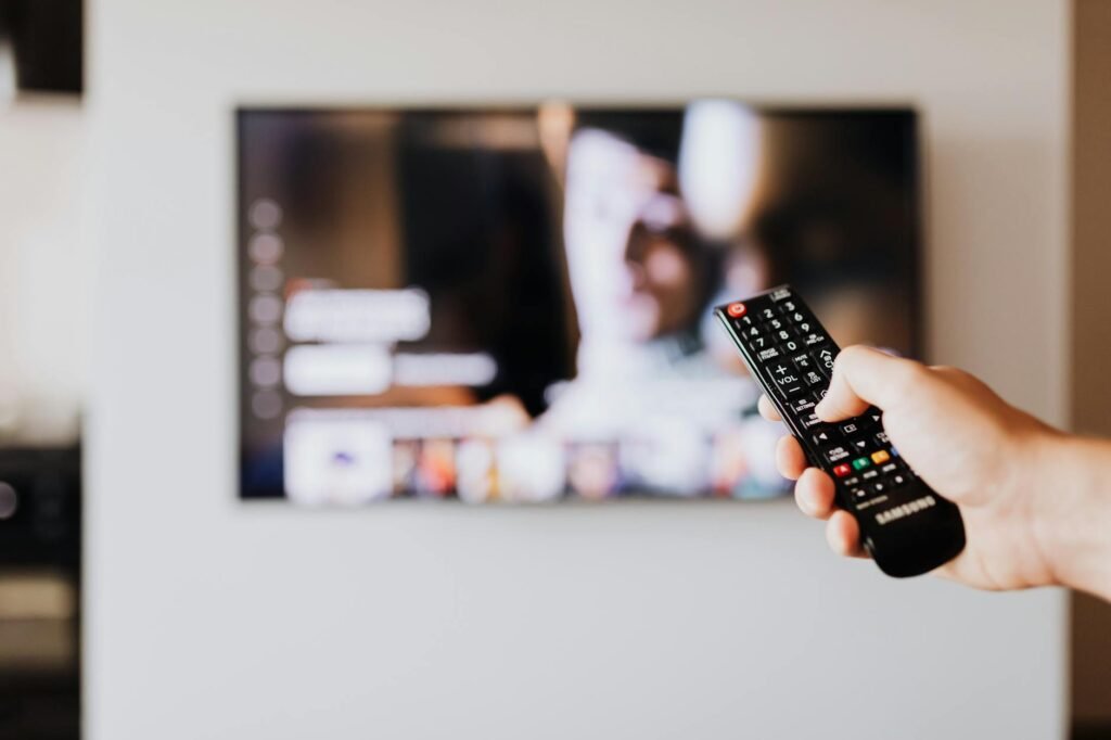 TVIP device showing IPTV interface on TV screen with remote control